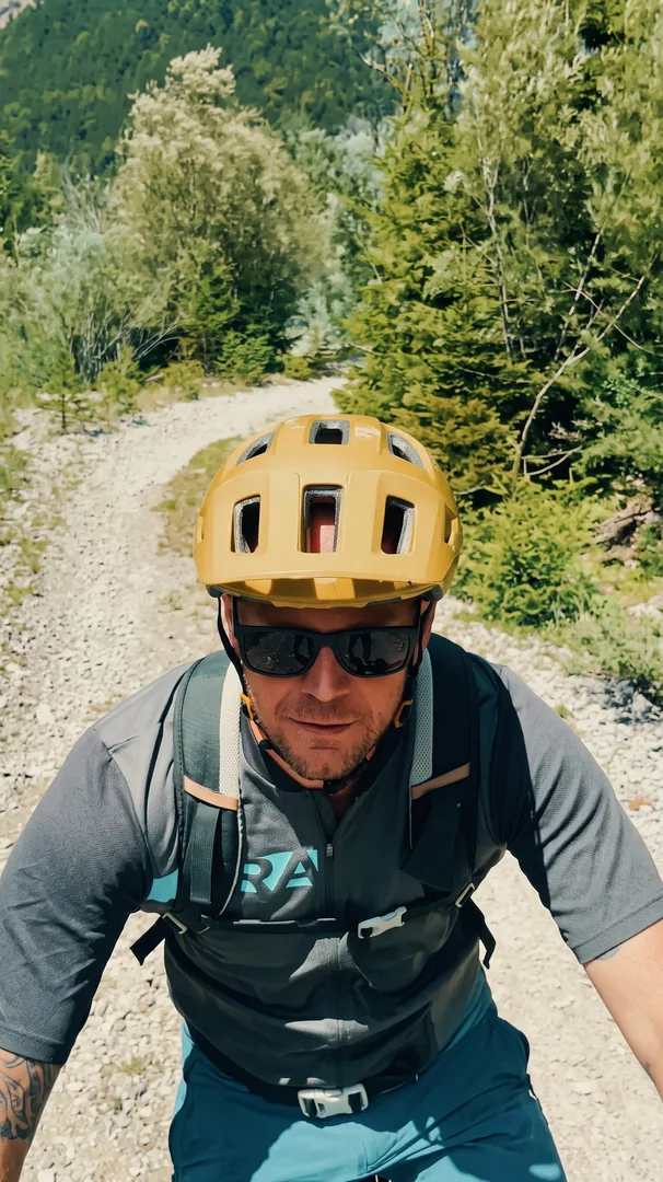 Eric mit gelbem Helm auf dem Schotterweg
