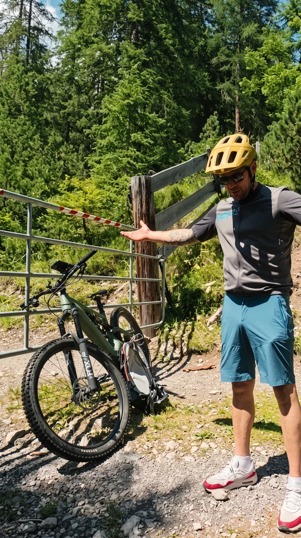 Eric neben seinem eMTB vor einem verschlossenen Tor
